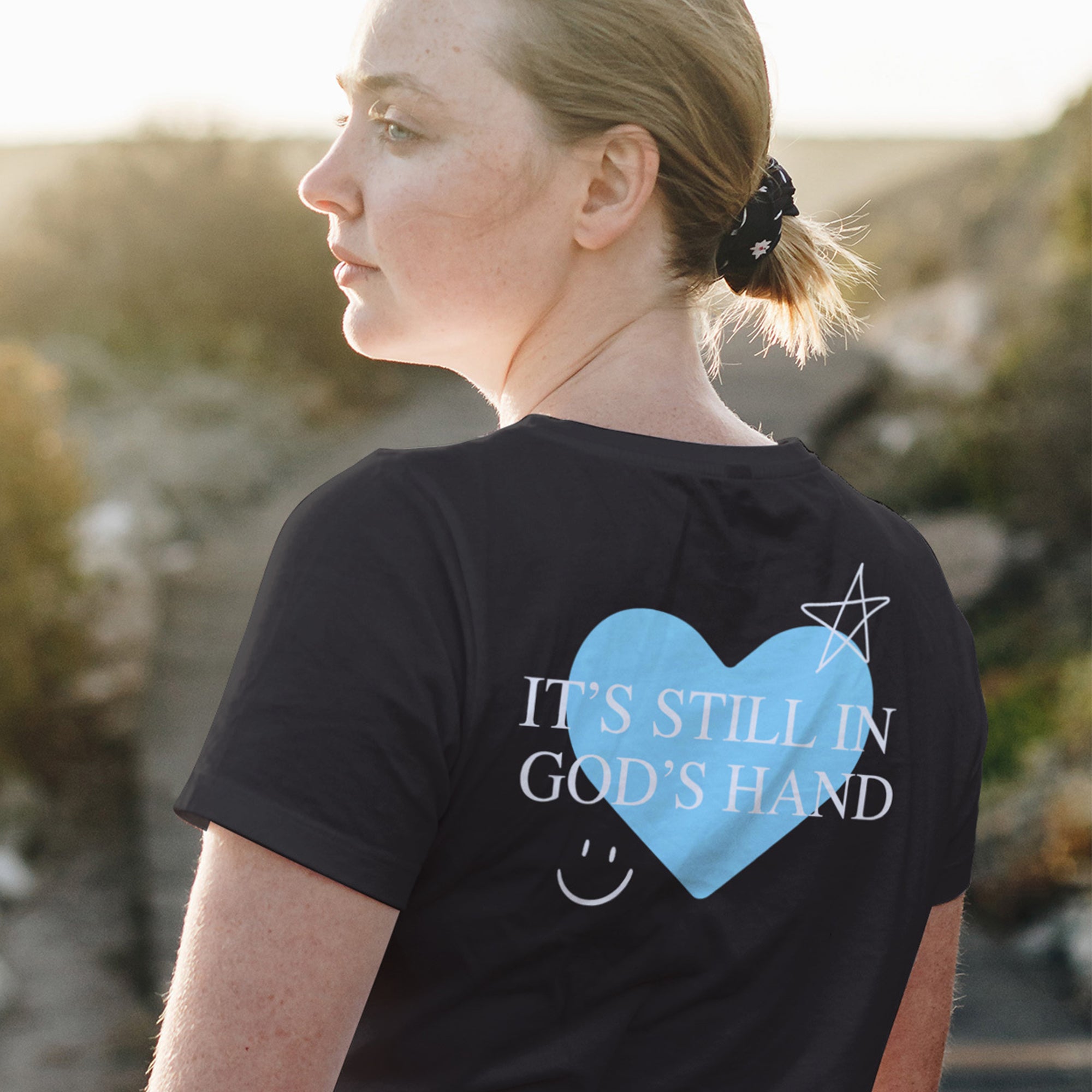 T-Shirt - It's Still In God's Hand